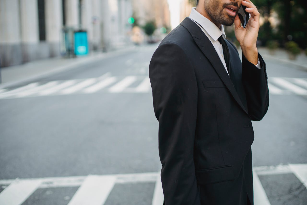 Crafting Captivating Headlines: Your awesome post title goes here Young businessman talking on mobile phone in a city street wearing a black suit.